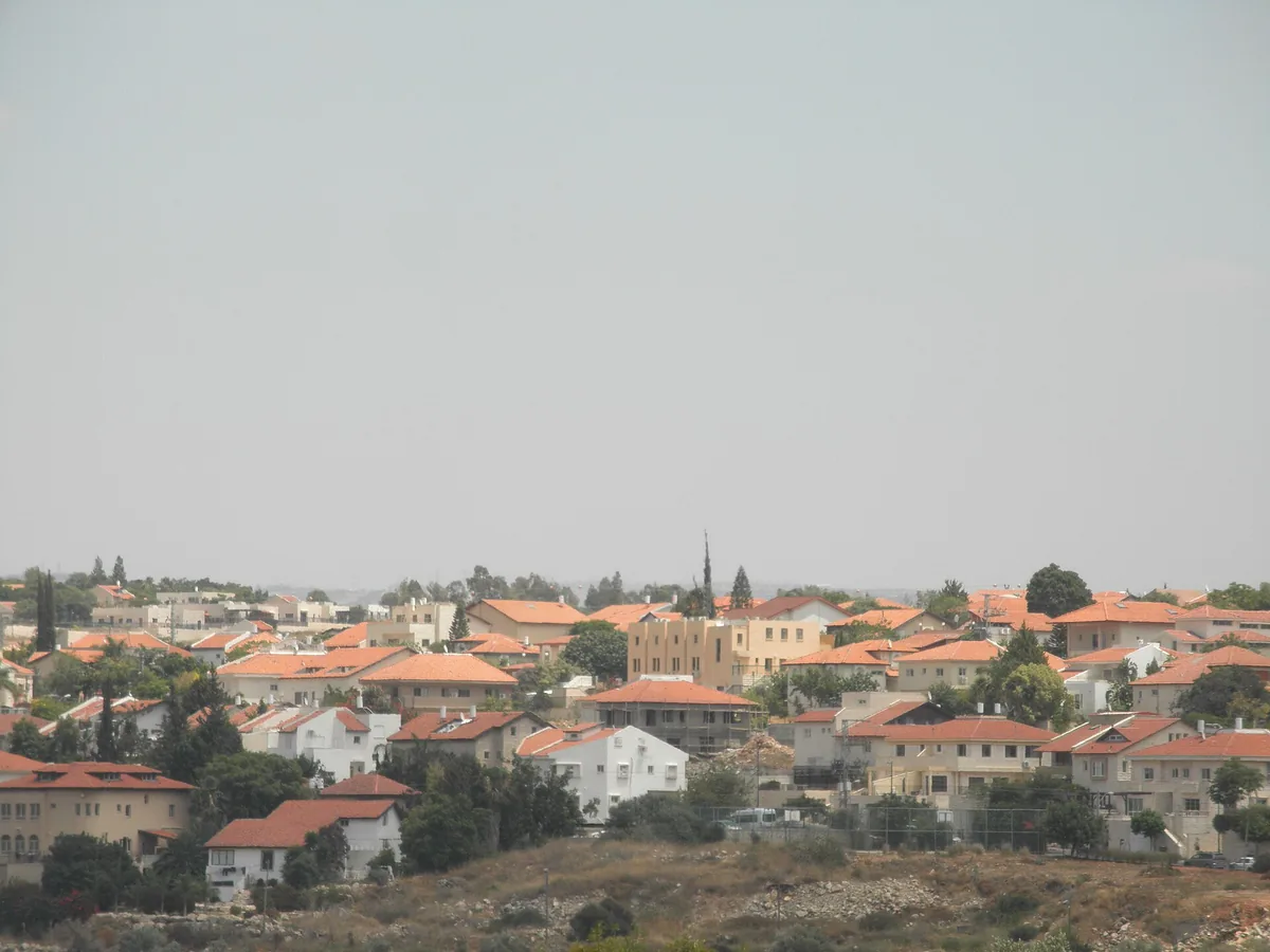 Hashmonaim's red-roofed houses spread across a hill, seen from the west