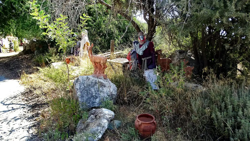 Figures in period dress and clay jars among plants at Kfar Hashmonai
